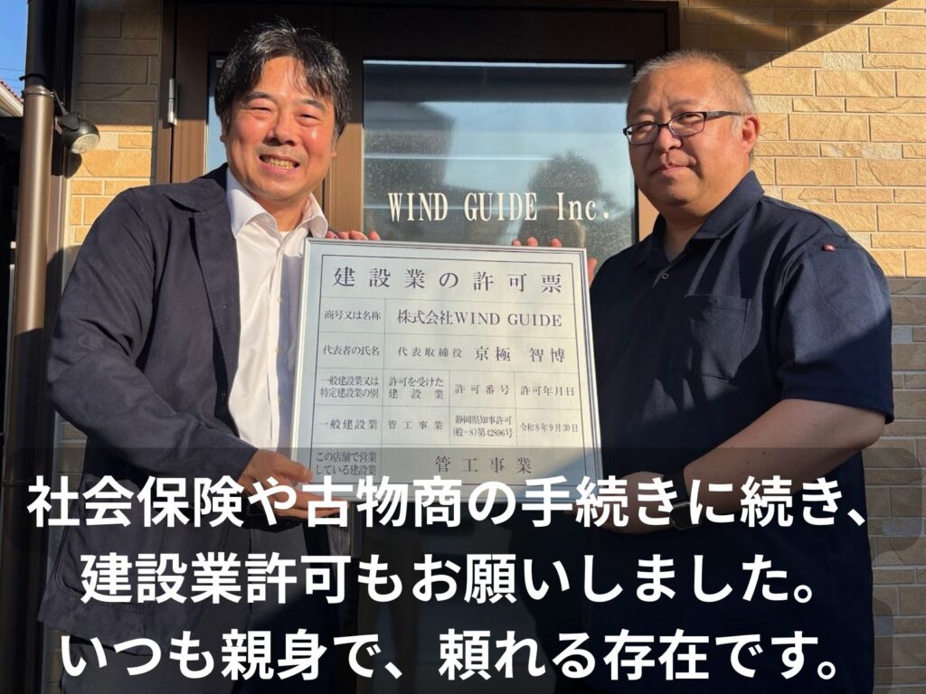 建設業の許可票を持つ株式会社WIND GUIDE代表・京極智博様と成岡寛人。「社会保険や古物商の手続きに続き、建設業許可もお願いしました。いつも親身で、頼れる存在です。」